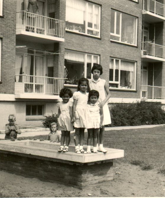 Indische kinderen aan de achterzijde van de flat aan de Jan van Brakelstraat in Wielwijk - Omstreeks jaren 1960